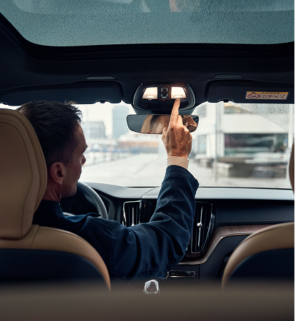 Volvo driver adjusting the rear-view mirror